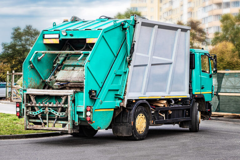 A garbage truck picks up garbage in a residential area. Separate collection and disposal of garbage. Garbage collection vehicle.