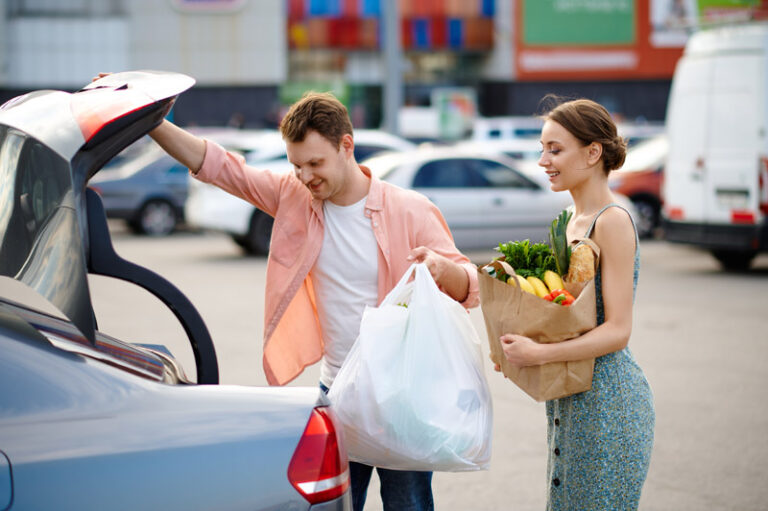 Family couple puts their purchases in the trunk